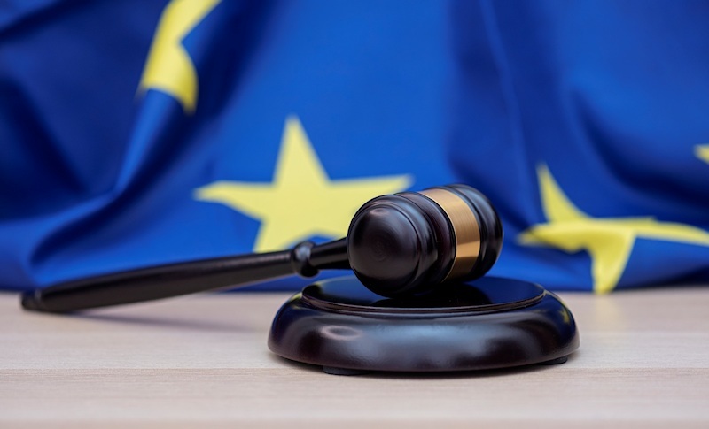 EU-Flagge im Hintergrund, Richterhammer im Vordergrund