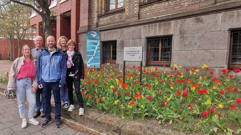5 Personen aus dem Arbeitskreis stehen vor dem Blumenfeld